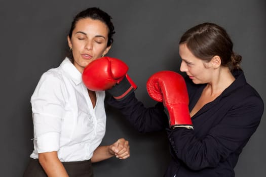 Two businesswomen with red boxing gloves