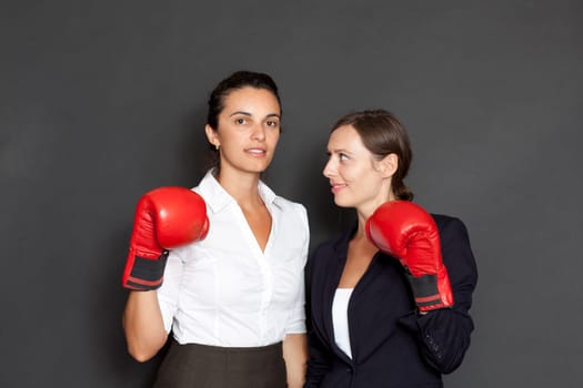 Two businesswomen with red boxing gloves