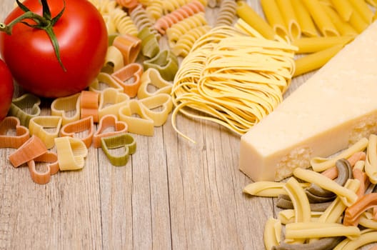 Various pasta,pecorino and tomato on a wooden board