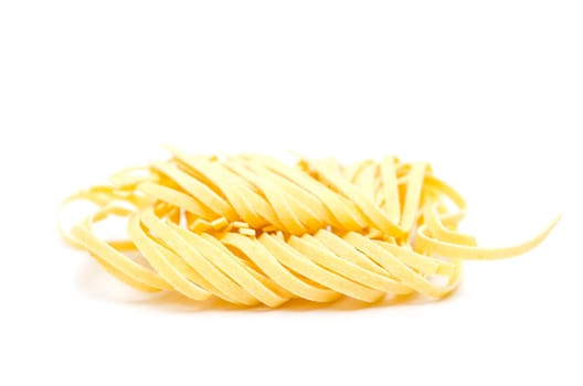 Yellow Taglerini pasta on white background
