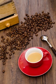 Espresso coffee in red cup with Arabica beans and coffee grinder