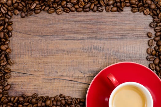 Cup espresso with beans on brown wood with text space