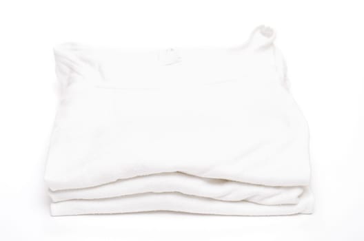 Three white undershirts on a pile