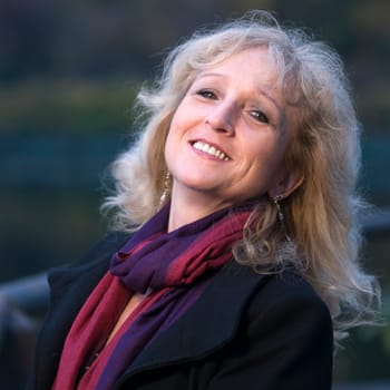 Portrait of a middle-aged blond curly woman at dusk