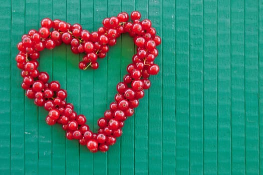 Heart-shaped currants on a green background with free text space