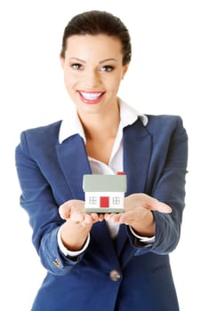 Beautiful young businesswoman holding house model over white - real estate loan concept