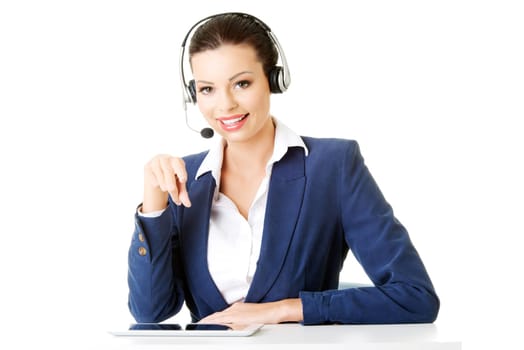 Beautiful young call-center assistant at the desk, isolated on white