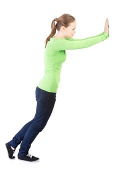 Woman pushing something imaginary isolated over a white background (white wall over her hands)