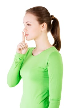 Hush be quiet woman isolated. Teen girl with finger on her lips.
