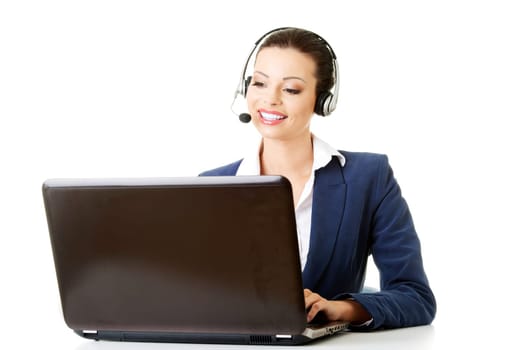 Beautiful young call-center assistant at the desk, isolated on white