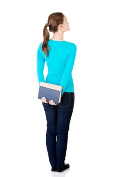 Back view of young student woman holding an old book. Isolated over white background.