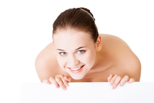 Beautiful woman with perfect skin and beautyful face holding blank board. Isolated on a White Background.