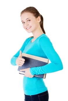 Attractive young student woman with book gesturing OK, isolated on white