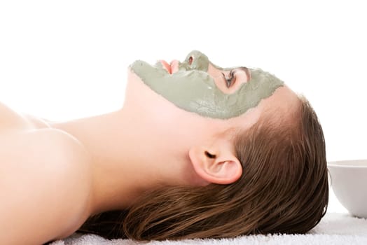Beauty treatment in spa salon. Woman with facial clay mask. Isolated on white