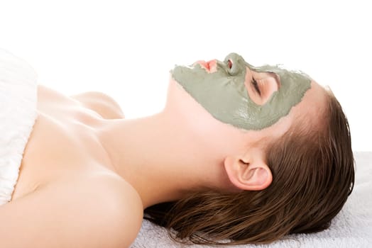 Beauty treatment in spa salon. Woman with facial clay mask. Isolated on white