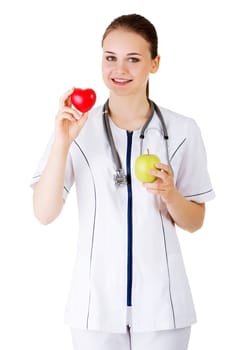 Healthy eating or lifestyle concept. Smiling woman doctor with a green apple and red heart.