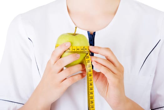 Healthy eating or diet concept. Smiling woman doctor with a green apple and measuring tape.