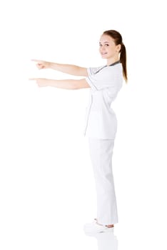 Woman doctor or nurse pointing on copy space. Isolated on white