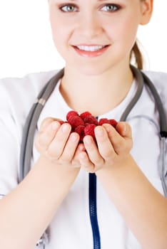 Healthy raspberries. Female doctor holding raspberries in hand.
