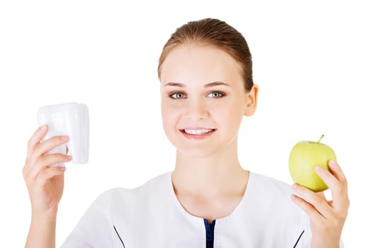 Female dentist with green apple and big tooth. Isolated on white