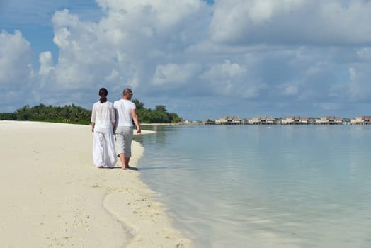 happy young couple have fun and relax at summer vacation on background maldives travel location and beautiful white sand beach