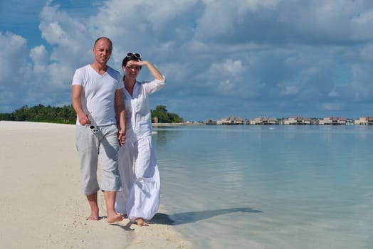 happy young couple have fun and relax at summer vacation on background maldives travel location and beautiful white sand beach