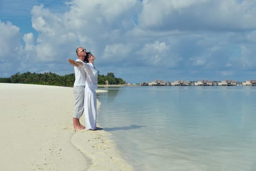 happy young couple have fun and relax at summer vacation on background maldives travel location and beautiful white sand beach