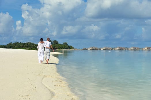 happy young couple have fun and relax at summer vacation on background maldives travel location and beautiful white sand beach