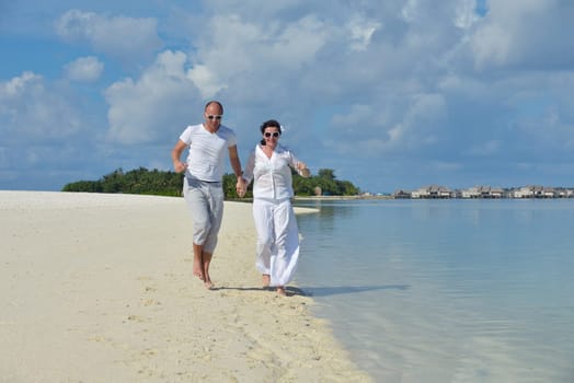 happy young couple have fun and relax at summer vacation on background maldives travel location and beautiful white sand beach