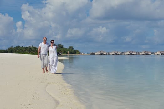 happy young couple have fun and relax at summer vacation on background maldives travel location and beautiful white sand beach