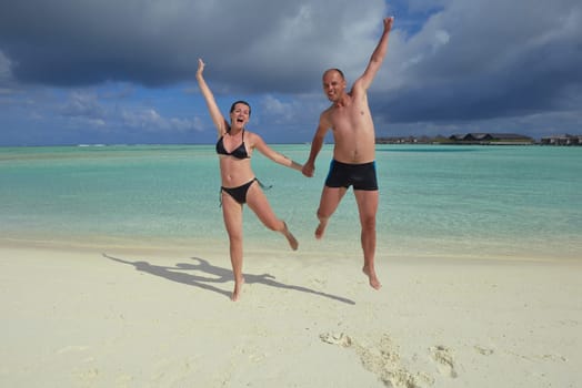 happy young couple have fun and relax at summer vacation on background maldives travel location and beautiful white sand beach