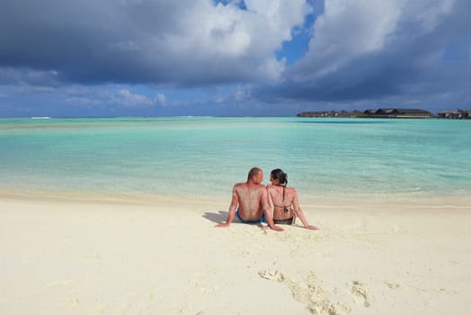 happy young couple have fun and relax at summer vacation on background maldives travel location and beautiful white sand beach