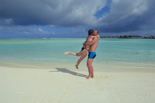 happy young couple have fun and relax at summer vacation on background maldives travel location and beautiful white sand beach
