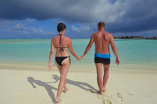 happy young couple have fun and relax at summer vacation on background maldives travel location and beautiful white sand beach