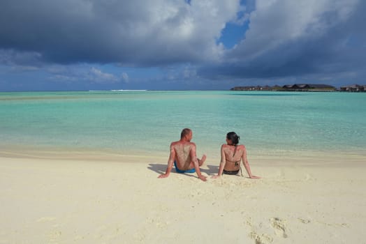 happy young couple have fun and relax at summer vacation on background maldives travel location and beautiful white sand beach