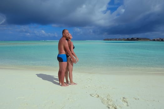 happy young couple have fun and relax at summer vacation on background maldives travel location and beautiful white sand beach