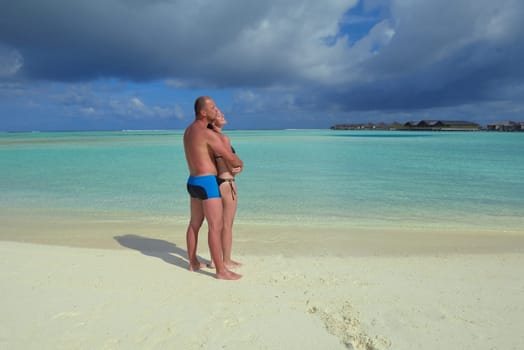 happy young couple have fun and relax at summer vacation on background maldives travel location and beautiful white sand beach