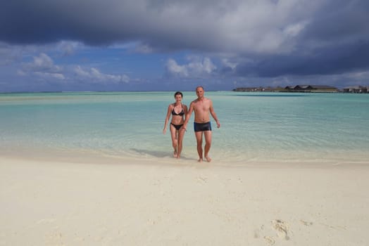 happy young couple have fun and relax at summer vacation on background maldives travel location and beautiful white sand beach