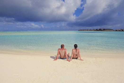 happy young couple have fun and relax at summer vacation on background maldives travel location and beautiful white sand beach