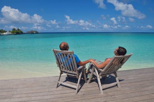 happy young couple have fun and relax at summer vacation on background maldives travel location and beautiful white sand beach