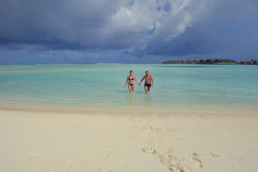 happy young couple have fun and relax at summer vacation on background maldives travel location and beautiful white sand beach