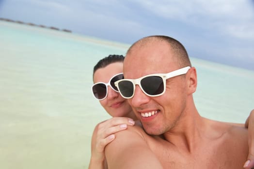 happy young couple have fun and relax at summer vacation on background maldives travel location and beautiful white sand beach