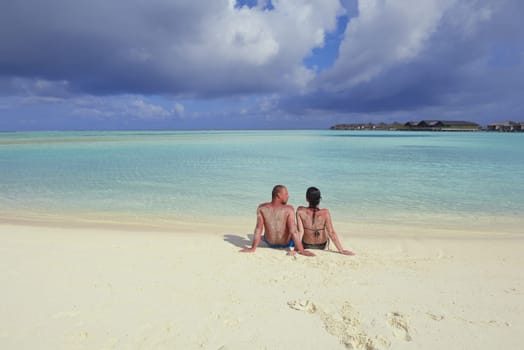 happy young couple have fun and relax at summer vacation on background maldives travel location and beautiful white sand beach