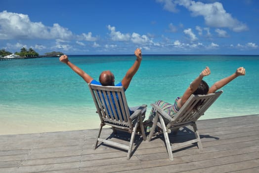 happy young couple have fun and relax at summer vacation on background maldives travel location and beautiful white sand beach