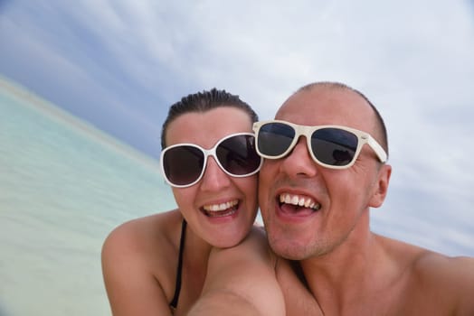 happy young couple have fun and relax at summer vacation on background maldives travel location and beautiful white sand beach