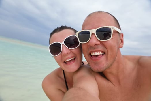 happy young couple have fun and relax at summer vacation on background maldives travel location and beautiful white sand beach