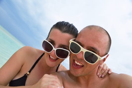 happy young couple have fun and relax at summer vacation on background maldives travel location and beautiful white sand beach