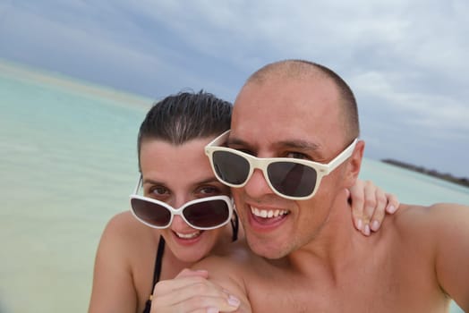 happy young couple have fun and relax at summer vacation on background maldives travel location and beautiful white sand beach