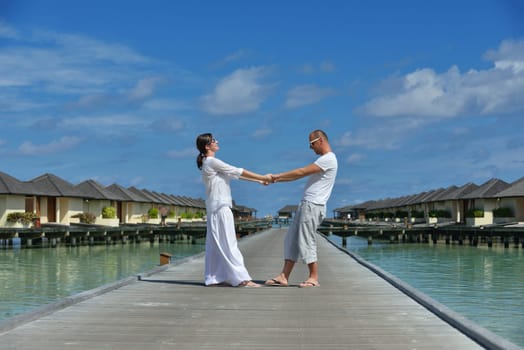 happy young couple have fun and relax at summer vacation on background maldives travel location and beautiful white sand beach