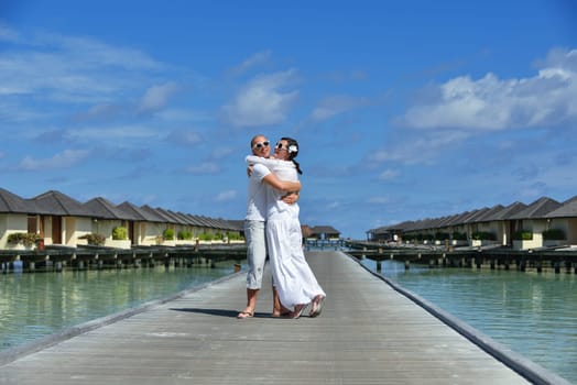 happy young couple have fun and relax at summer vacation on background maldives travel location and beautiful white sand beach